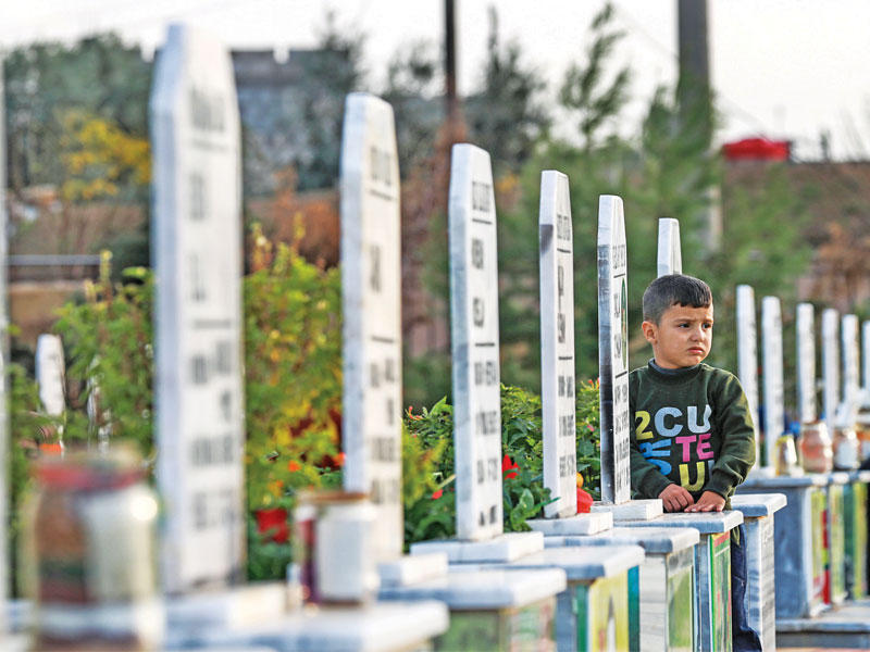 صبي سوري في مقبرة للمقاتلين الأكراد في القامشلي أمس الأول (أ ف ب)n