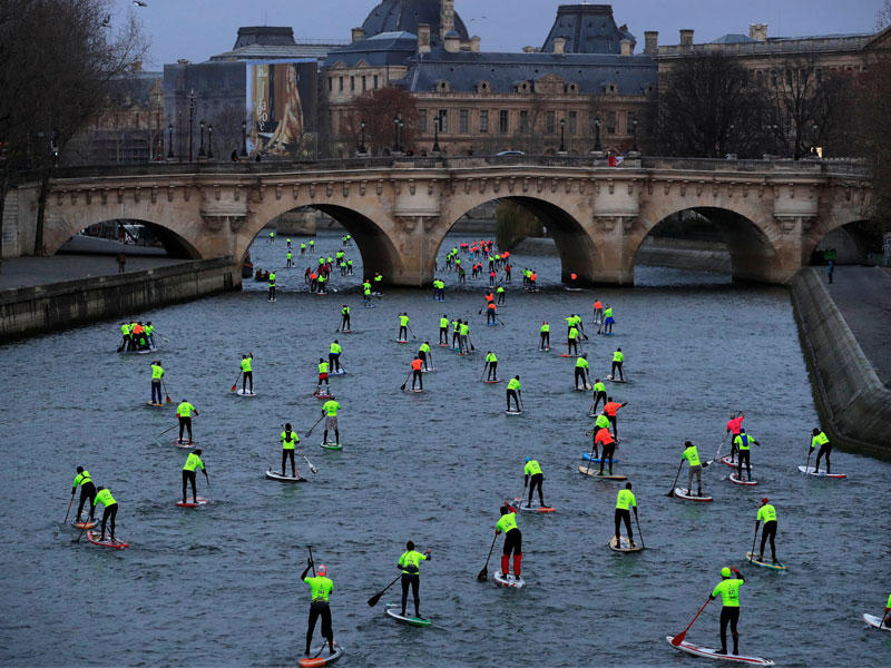 فرنسيون يشاركون في سباق للتجديف في نهر السين أمس (رويترز)n