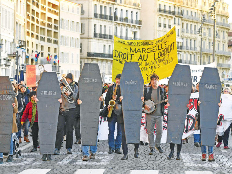فرنسيون يحملون نعوشاً خلال احتجاجات على شروط السكن في مدينة مارسيليا أمس (ا ف ب)