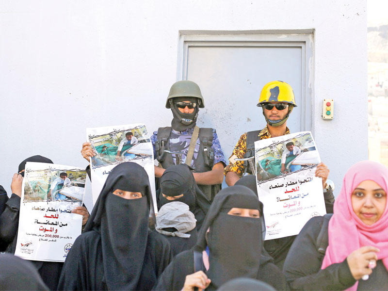 يمنيات يطالبن بإعادة فتح مطار العاصمة خلال وقفة احتجاجية أمام مكتب الأمم المتحدة بصنعاء أمس (رويترز)