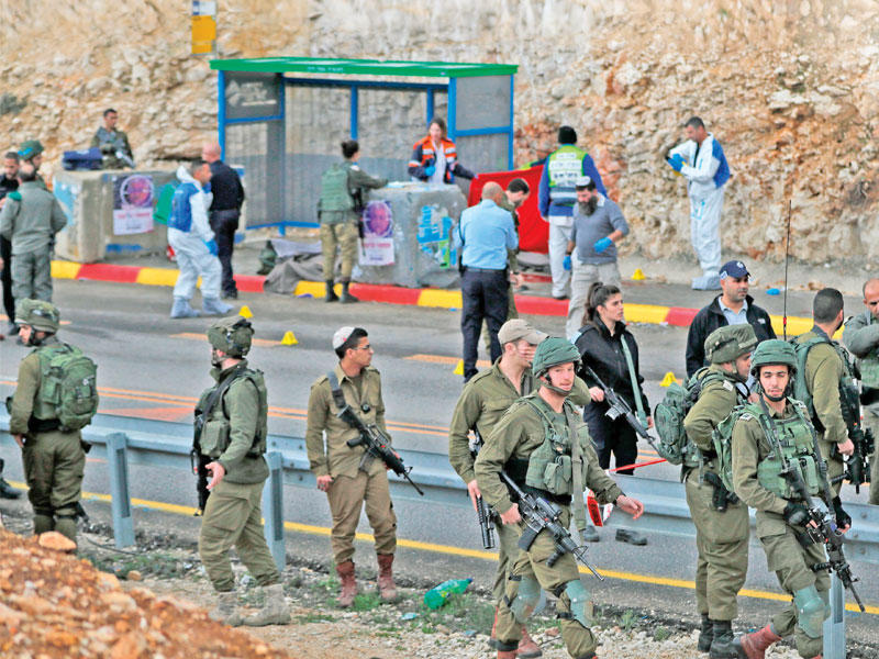 قوة أمنية إسرائيلية في موقع الهجوم بمستوطنة غيفات أساف أمس (أ ف ب)