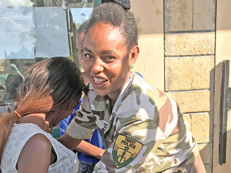 شرطية من عرق تيغراي تفتش فتاة على مدخل متحف حربي في مكيليلي (رويترز)