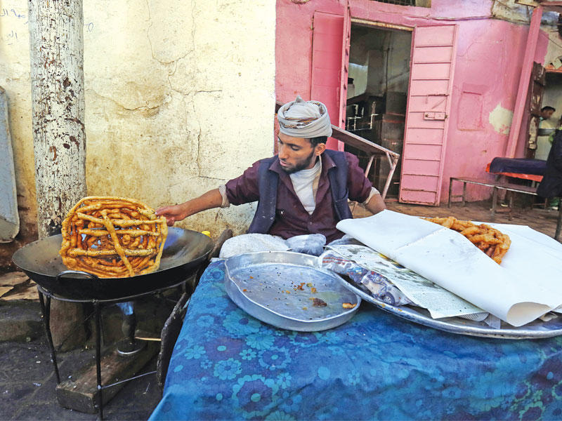 يمني يعد فطائر في سوق شعبي بصنعاء أمس (إي بي أيه)
