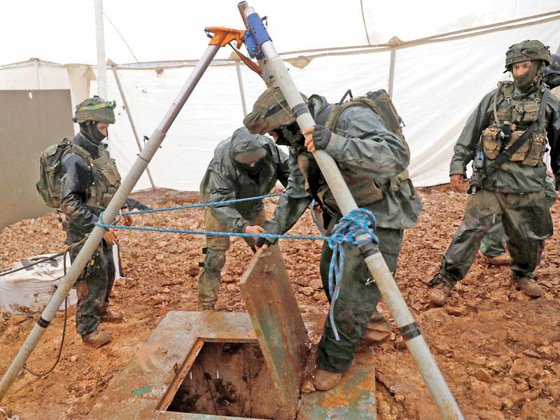 جنود إسرائيليون على باب أحد الأنفاق قرب الخط الأزرق على الحدود مع لبنان (رويترز)
