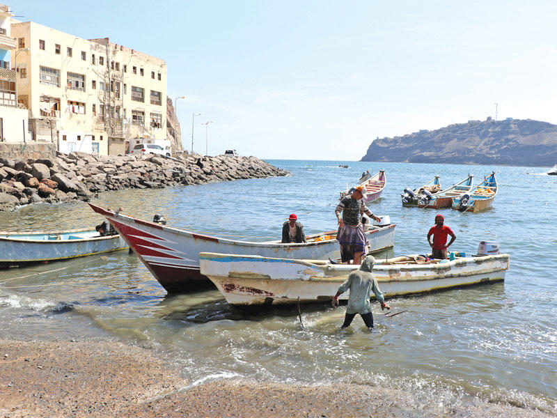 صيادون على متن قارب قرب ميناء في عدن أمس (رويترز)