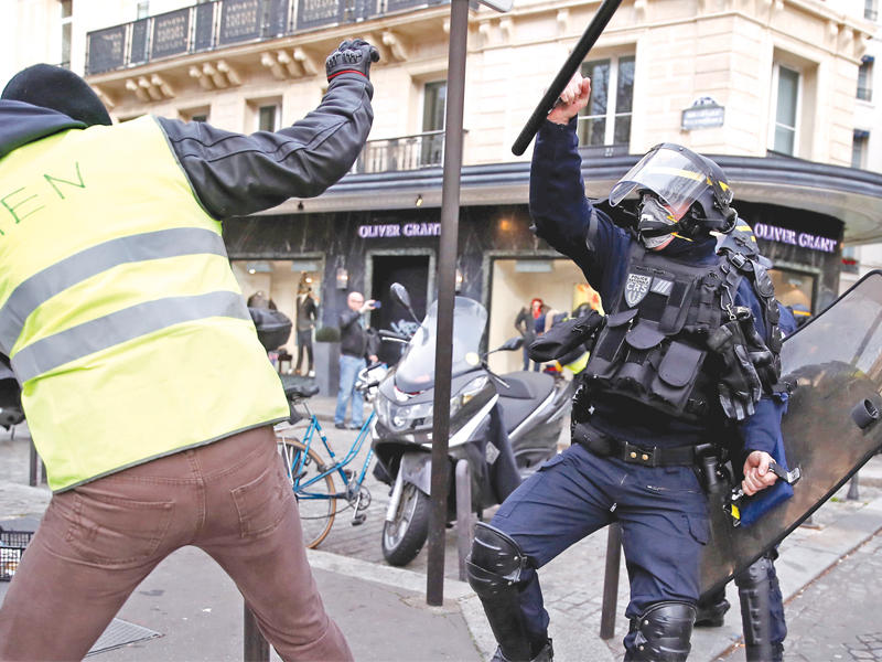 شرطي يضرب أحد محتجي «السترات الصفراء» في باريس أمسt(رويترز)