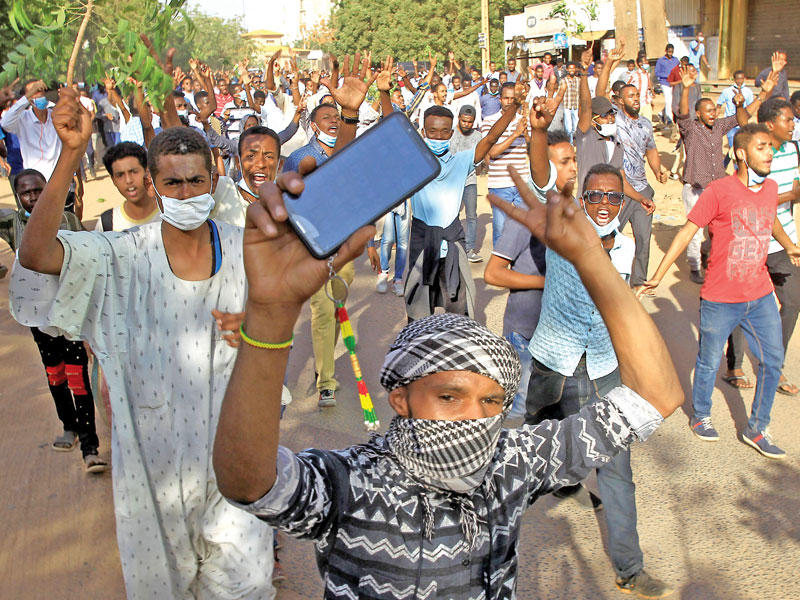 سودانيون يرددون شعارات ضد الحكومة في الخرطوم أمس (رويترز)