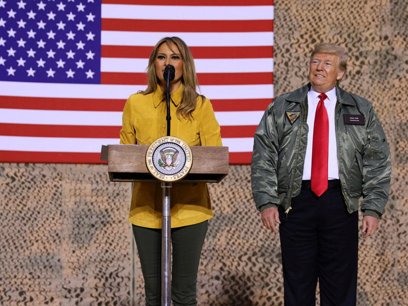 ترامب مستمعاً إلى زوجته خلال إلقائها كلمة أمام الجنود الأميركيين في قاعدة الأسد الجوية مساء أمس الأول (رويترز)