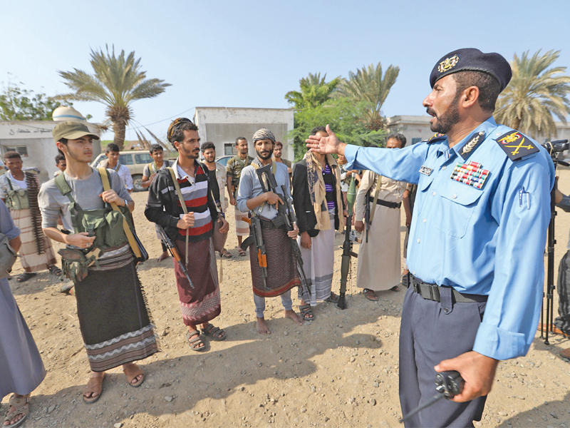 قائد خفر السواحل الموالي لـ«أنصار الله» عبدالرزاق المؤيد متحدثاً إلى عناصر «الميليشيات الحوثية» قبل انسحابها من ميناء الحديدة أمس (رويترز)