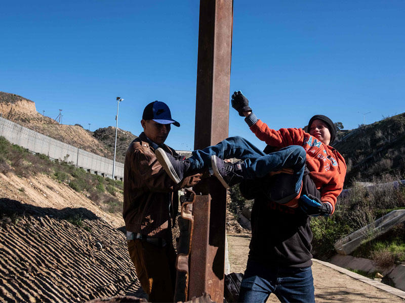 مهاجرون من أمريكا الوسطى يأملون في الوصول إلى الولايات المتحدة عبر السياج الحدودي بين الولايات المتحدة والمكسيك