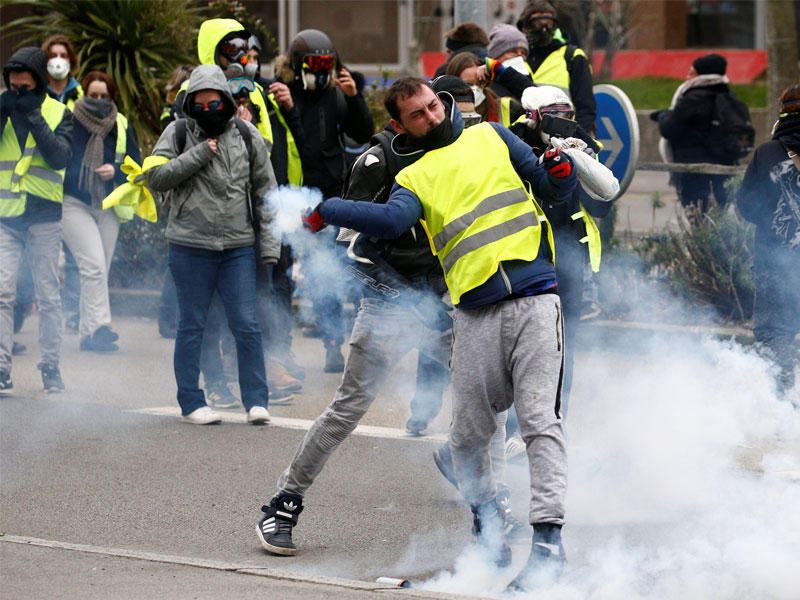 متظاهر يرتدي سترة صفراء يتفاعل خلال مظاهرة