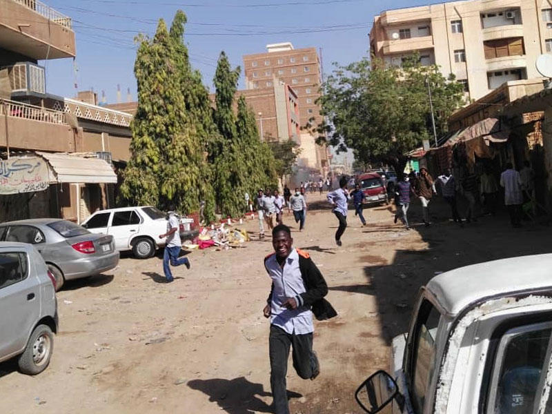 سودانيون يهربون من قنابل الغاز المسيل للدموع في الخرطوم (أ ف ب)