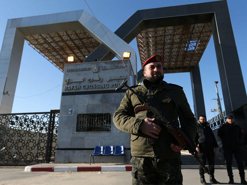 عنصر أمن موال لـ«حماس» على بوابة معبر رفح أمس (رويترز)