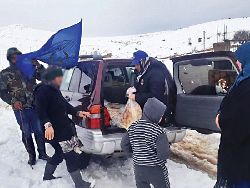توزيع الخبز على أسر في إحدى قرى بعلبك التي حاصرها الثلج أمس (الوكالة الوطنية)
