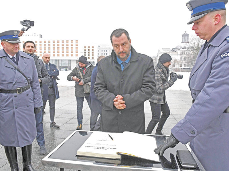 سالفيني يستعد لكتابة كلمة في دفتر على ضريح الجندي المجهول في وارسو أمس الأول (ا ف ب)