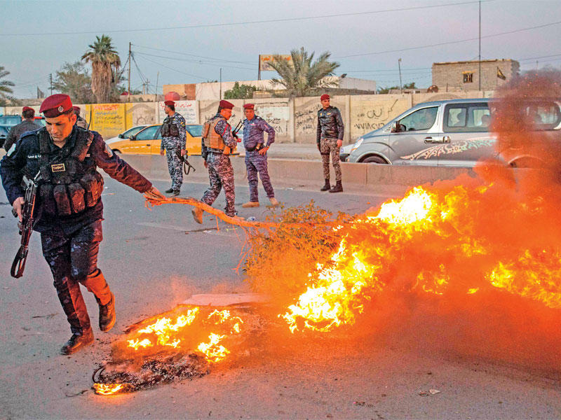 عنصر أمني خلال فض تظاهرة بالبصرة أمس الأول (أ ف ب)