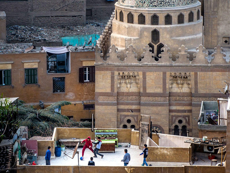 فتية مصريون يلعبون بالكرة على أحد الأسطح في القاهرة  (أي بي أيه)