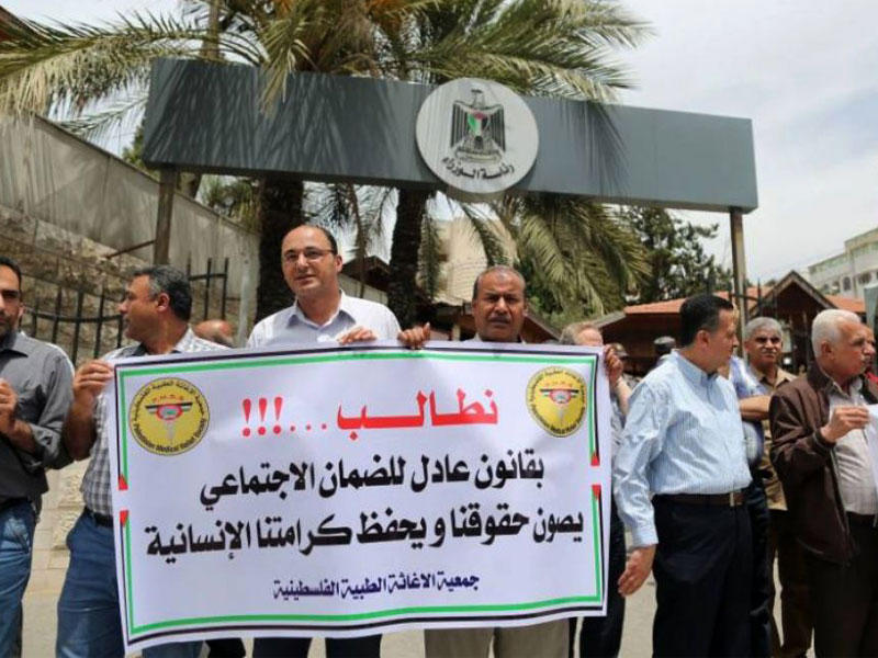 متظاهرون فلسطينيون يتجمّعون عند مكتب رئيس الوزراء الفلسطيني في رام الله احتجاجاً على قانون الضمان الاجتماعي الجديد