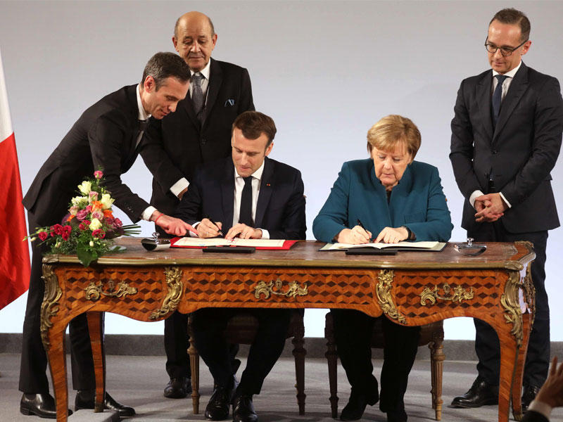 ميركل وماكرون يوقعان المعاهدة في جنوب ألمانيا أمس (أ ف ب)