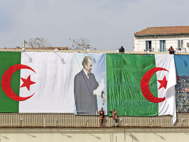 صورة أرشيفية لبوتفليقة على علم جزائري ضخم في العاصمة الجزائر (رويترز)