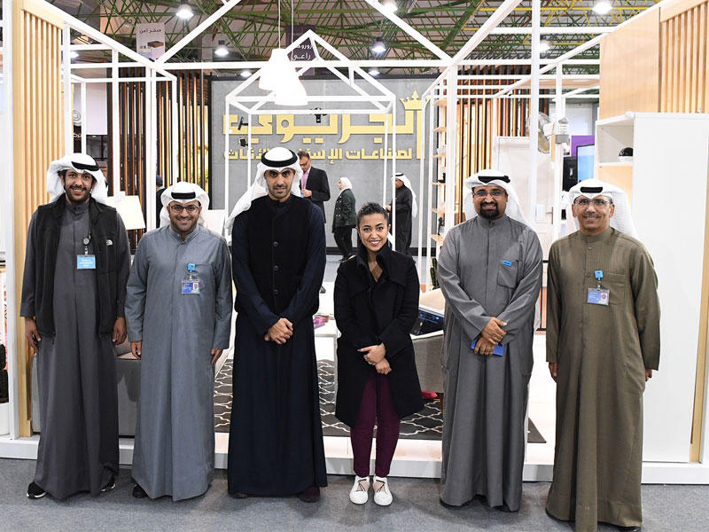 الخرافي يتوسط الحميضي وفريق «زين» في جناح الشركة بالمعرض