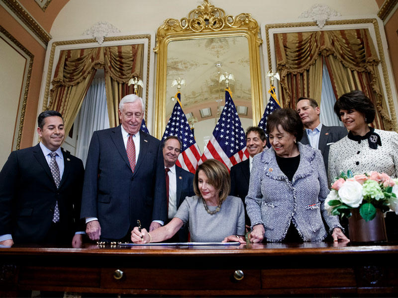 بيلوسي محاطة بعدد من النواب خلال توقيعها اتفاق وقف الإغلاق أمس الأول في واشنطن (اي بي ايه)