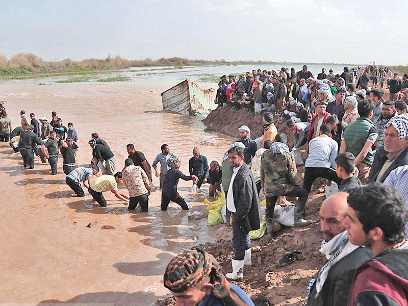 إيرانيون بمدينة رافي التابعة لخوزستان يعيدون إقامة سد ترابي على نهر بعد أن غمرت المياه قرى ومدناً بالمحافظة التي تسكنها غالبية عربية أمس                (ميزان)