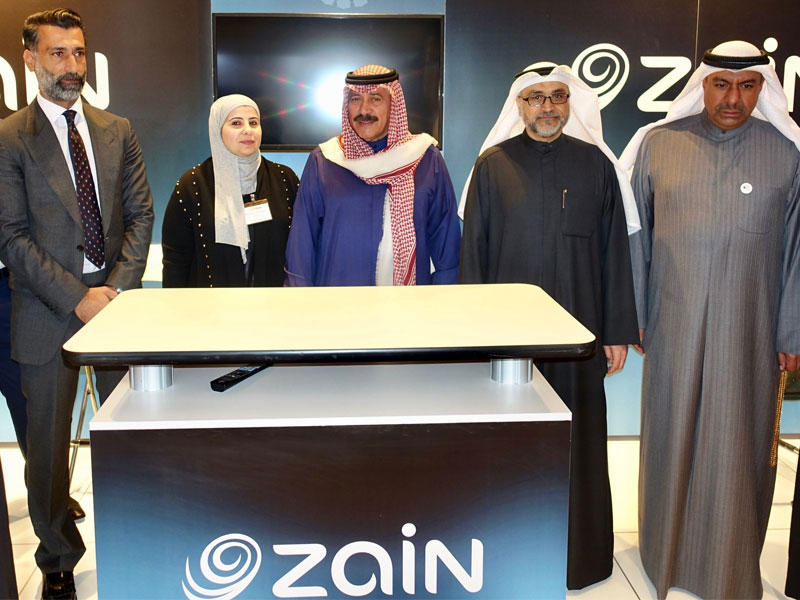 الدوسري يتوسط مشعل محمد وفريق زين في جناح الشركة