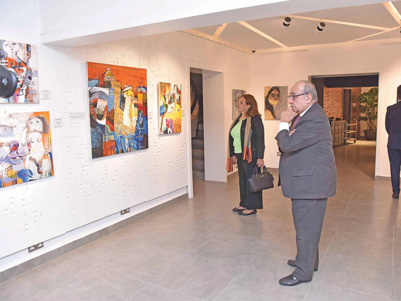 جانب من اللوحات في معرض « الهجرة السورية» ويبدو السيد محمد ناجيا