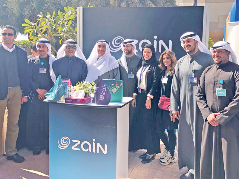 الخرافي والأنصاري يتوسطان فريق «زين» في جناح الشركة 