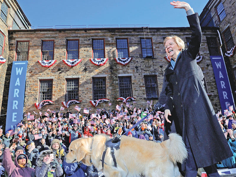 وارن مع كلبها بايلي بعد إطلاق حملتها في ماساشوستس أمس الأول (رويترز)