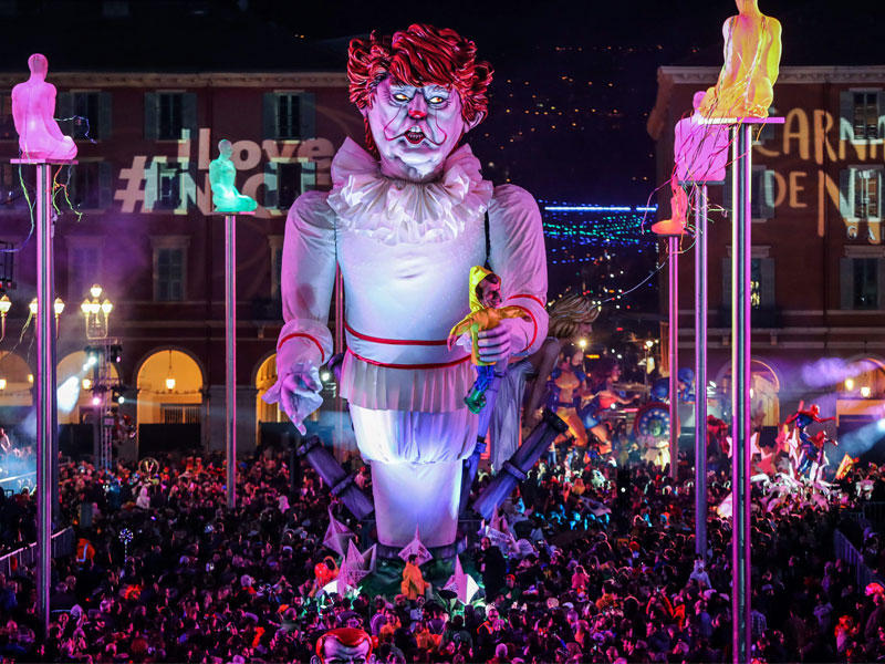 مجسّم عملاق لترامب حاملاً دمية تجسّد نظيره الفرنسي خلال استعراض كرنفالي في مدينة نيس الفرنسية أمس الأول (أ ف ب)