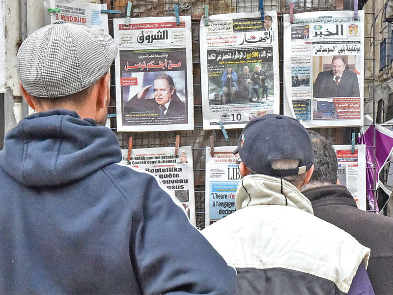 جزائريون يطالعون الصحف في أحد أكشاك العاصمة قبل أيام (أ ف ب)