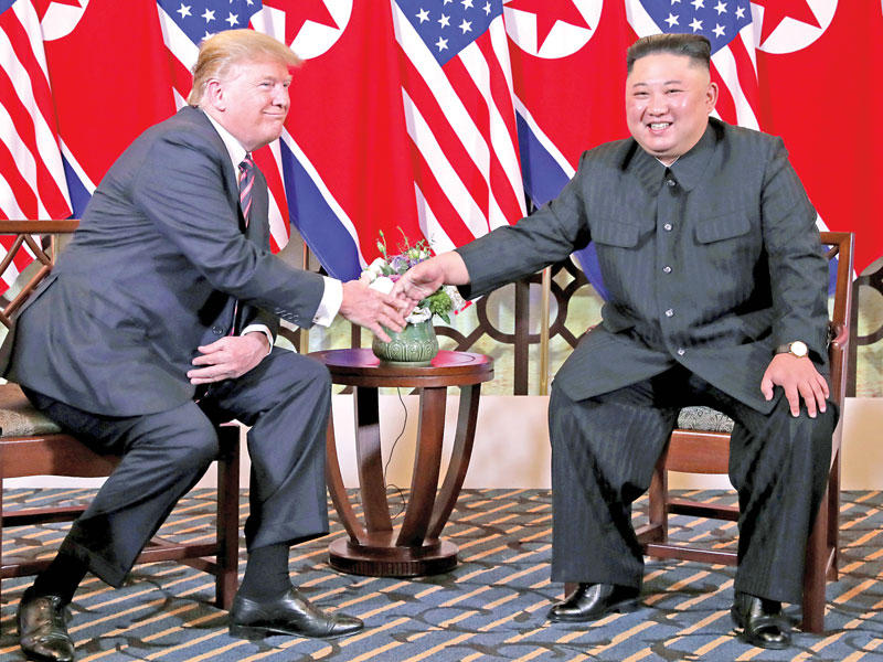 مصافحة بين ترامب وكيم في هانوي أمس (رويترز)