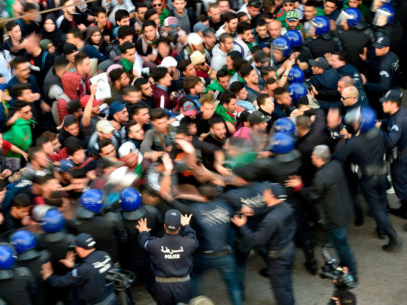 رجال شرطة مكافحة الشغب الجزائريون يدفعون الطلاب المتظاهرين في العاصمة الجزائر