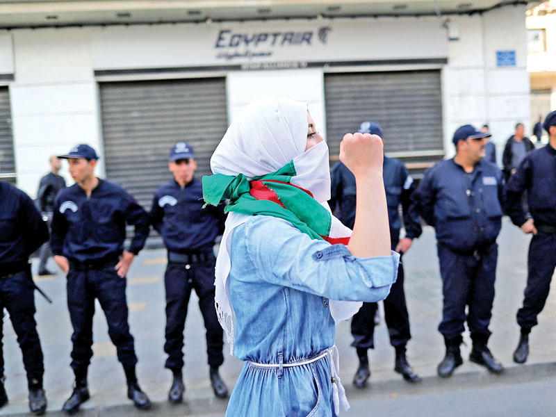 طالبة تتظاهر ضد العهدة الخامسة وسط العاصمة الجزائرية التي شهدت تعزيزات أمنية أمسt(رويترز)