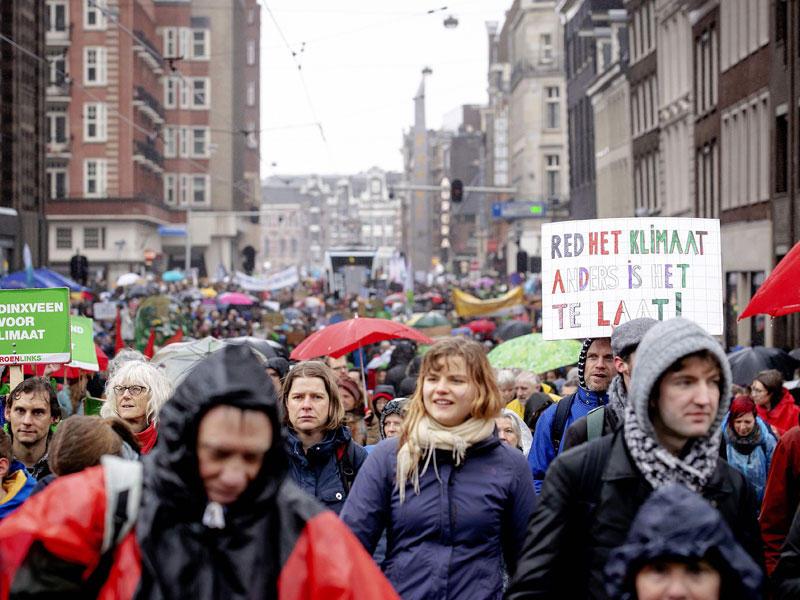 يشارك الناس في مسيرة لدعم المناخ