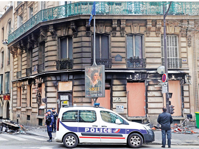 سيارة قرب محلات تعرّضت للحريق في الشانزيليزيه أمس (أ ف ب)