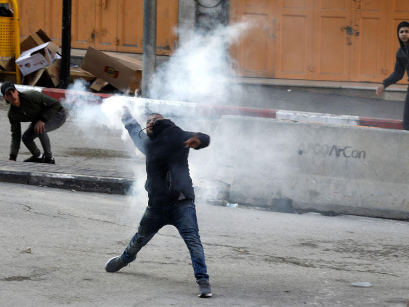 فلسطيني خلال مواجهات في الضفة أمس (آي بي إيه)