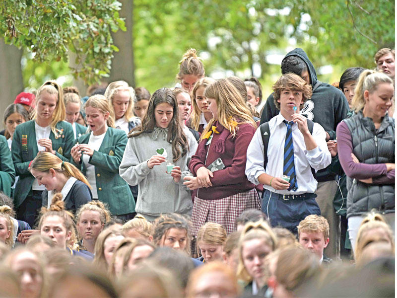 طلاب يقفون حداداً على أرواح ضحايا المسجدين في مدينة كرايستشيرش أمس (أ ف ب)n