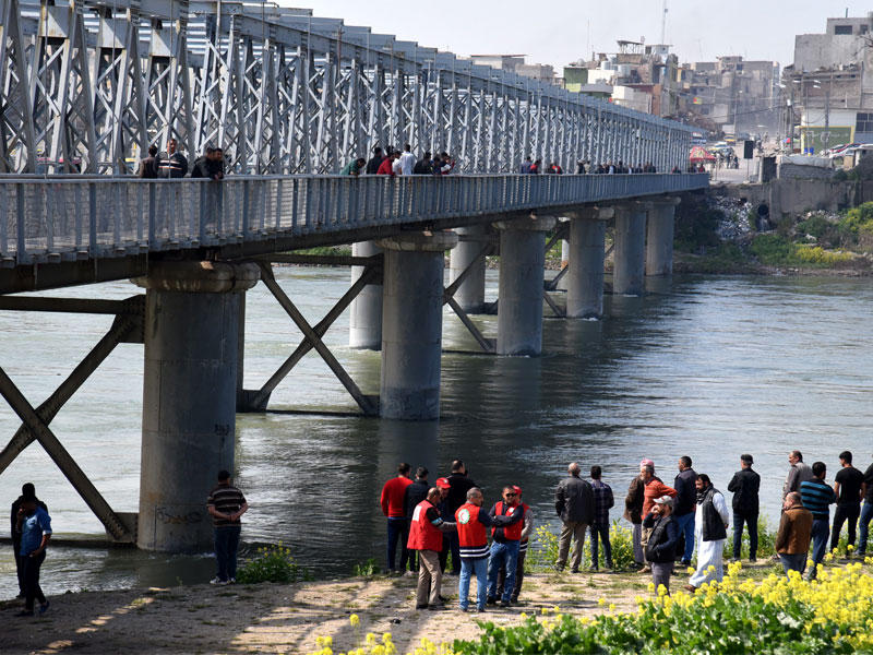 عراقيون على ضفاف دجلة أمس يراقبون عمليات انتشال جثث الضحايا  (أي بي أيه)