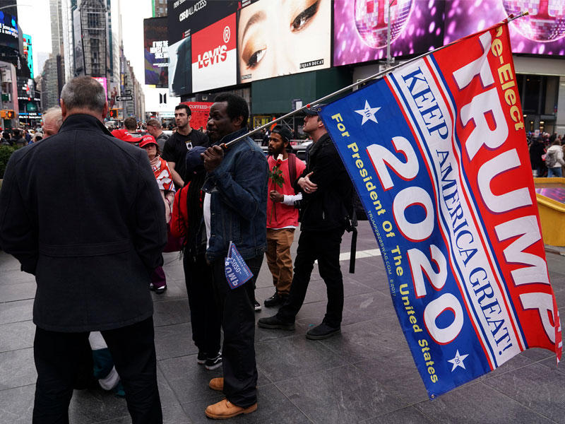 مناصرون لترامب يتجمعون في تايمز سكوير بنيويورك أمس الأول بعد إعلان ملخص تقرير مولر   (رويترز)