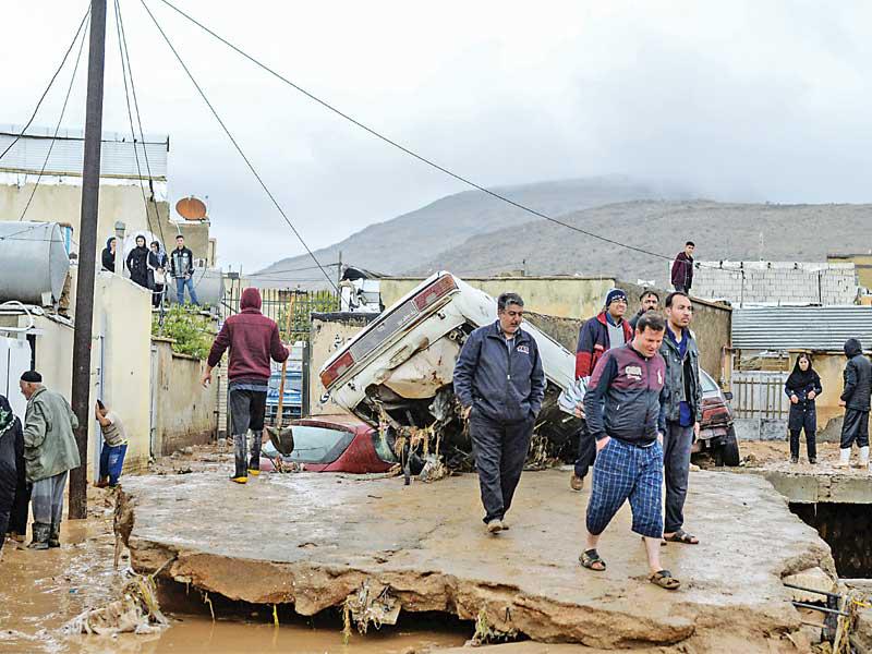 إيرانيون بمنطقة ضربها فيضان في شيراز أمس (رويترز)