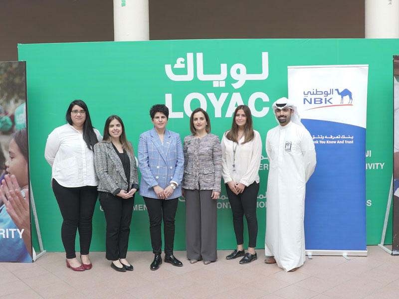 منال المطر وفاديا المرزوق تتوسطان فريق عمل البنك والمؤسسة