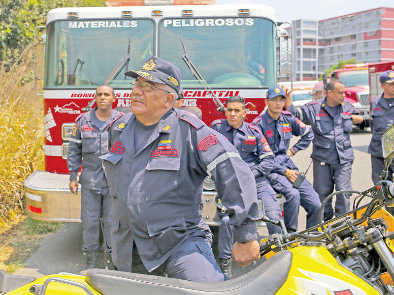 رجال إطفاء يراقبون حريق شبّ بأحد أعمدة التغذية الكهربائية في كراكاس أمس الأول (أ ف ب)