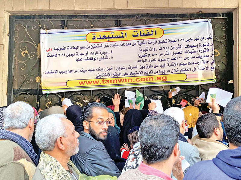 مصريون بمقر تابع لوزارة التموين بعد تعديل شروط الحصول على «بطاقة الدعم» في القاهرة أمس (رويترز)