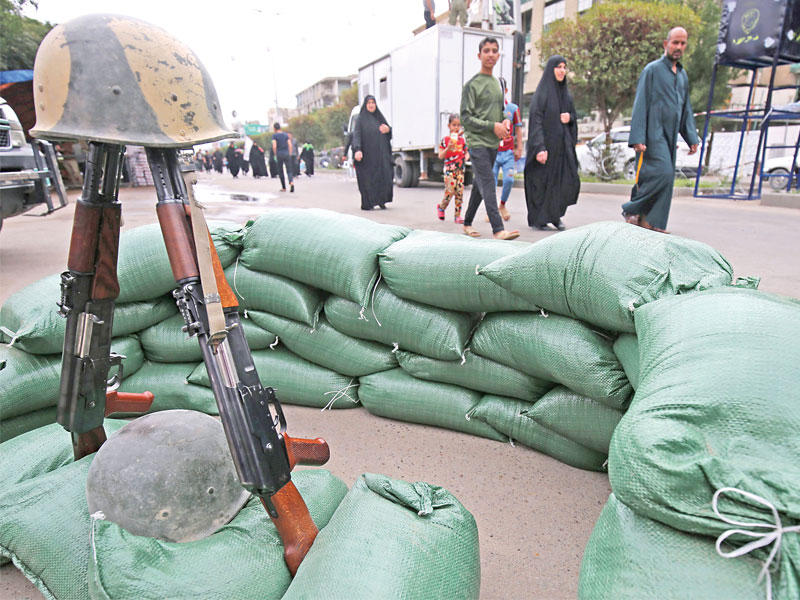 زوار شيعة في طريقهم إلى الكاظمية لإحياء ذكرى الإمام الكاظم يمرون قرب حاجز عسكري في بغداد أمس الأول (أ ف ب)