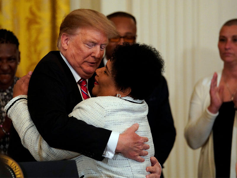 ترامب محتضناً السجينة السابقة أليس جونسون خلال حفل في البيت الأبيض أمس الأول (رويترز)