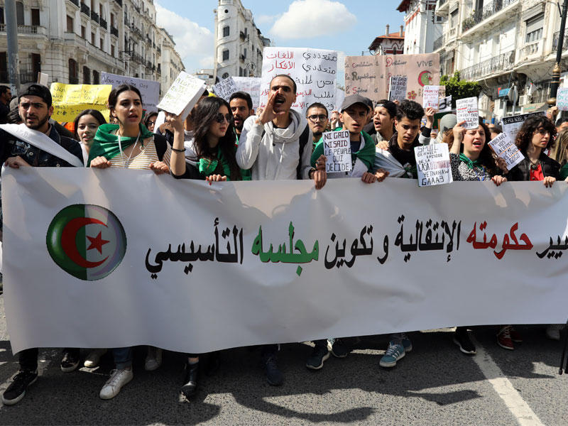 طلاب جزائريون يحملون لافتة خلال احتجاج ضد الحكومة الحالية في الجزائر العاصمة