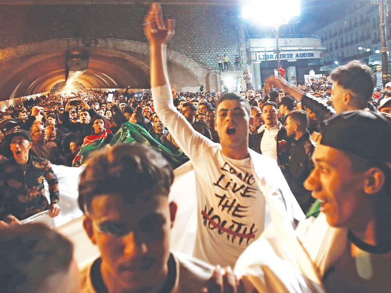 جزائريون يحتلفون بإعلان بوتفليقة الاستقالة أمس الأول (رويترز)